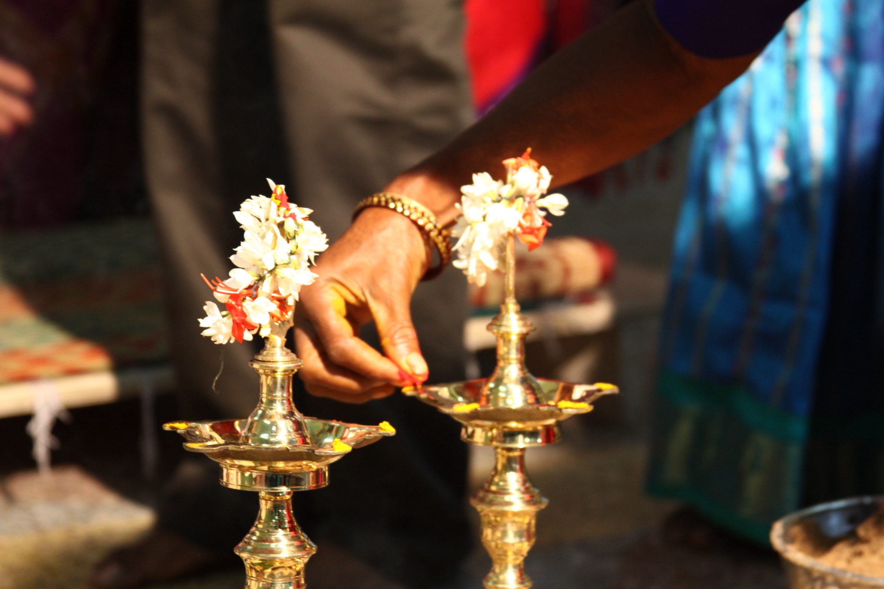 Hands lighting brass kuthu vilakku lamps